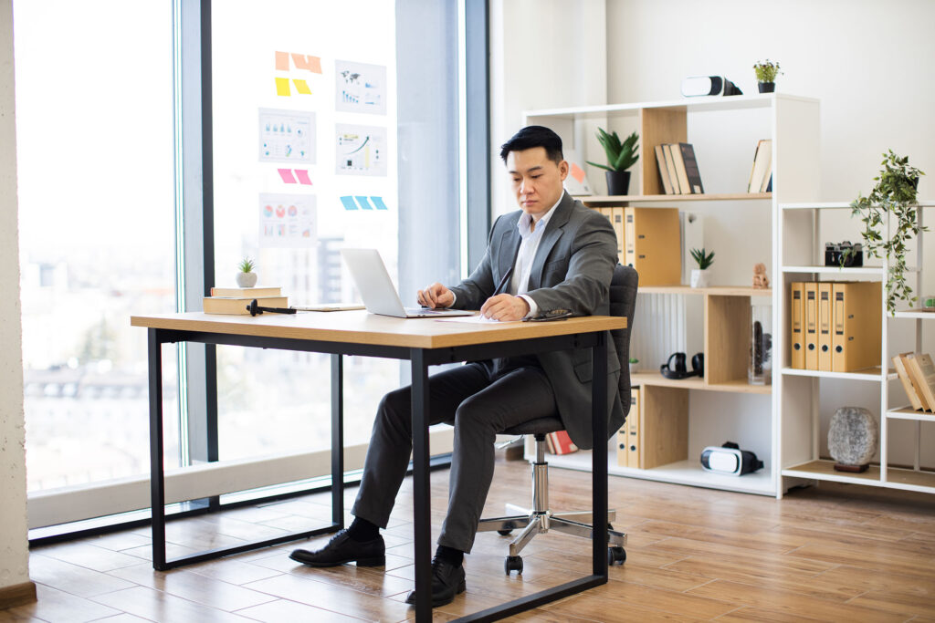 Man in a business suit seated at a desk writing an impactful video script